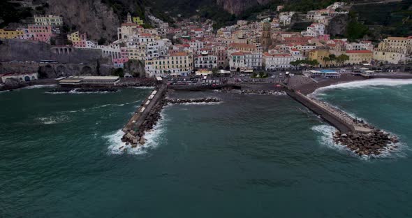 Aerial reveal of gorgeous coastal town in rugged cliffside setting, Amalfi
