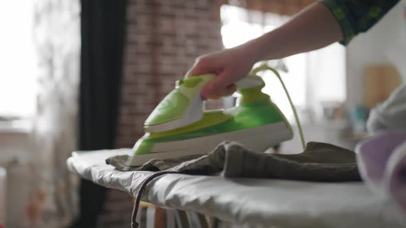 Female Hands Ironing Beige Wrinkled Clean Shorts