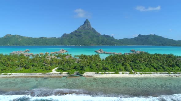 Aerial drone view of a luxury resort and overwater bungalows in Bora Bora tropical island