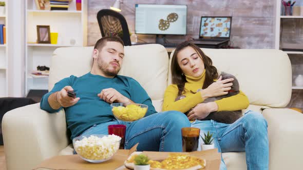 Young Couple Relaxing on the Couch with Their Cat