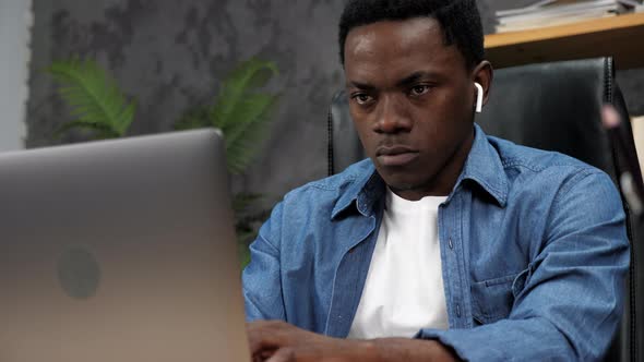 African American Man Works for Laptop Online Chatting with Company Employees