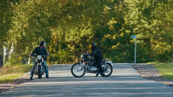 Two Brutal Men Motorcyclists Standing on the Road By Each Other and Getting Ready for the Race