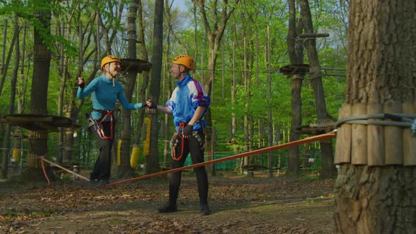 Girl slacklining in an adventure park