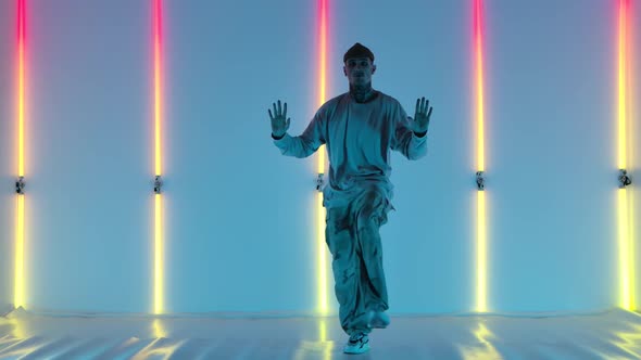 Cool Young Talented Hip Hop Guy Is Dancing Against the Backdrop of Bright Neon Lights Performing