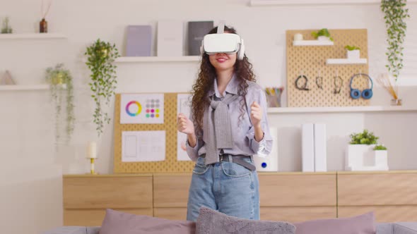 Asian woman using VR virtual reality glasses headset dancing in metaverse world. Young woman goggle