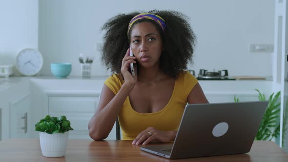 Multitasking Young Successful African Woman in Casual Wear Working Remotely on Laptop Planning New