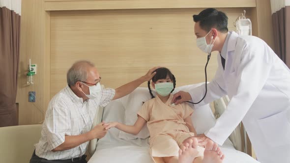 Asian doctor measure heart rate by stethoscope on little kid patient on bed in recovery room.