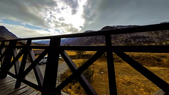 Timelapse of Wooden Fence on High Terrace at Mountain Landscape with Clouds. Horizontal Slider