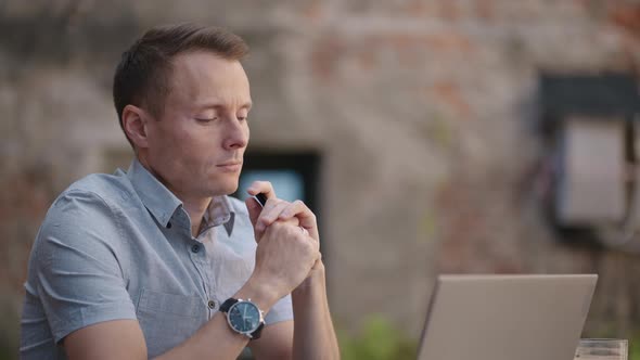 Thoughtful 30s Man Thinking of Problem Solution Working on Laptop