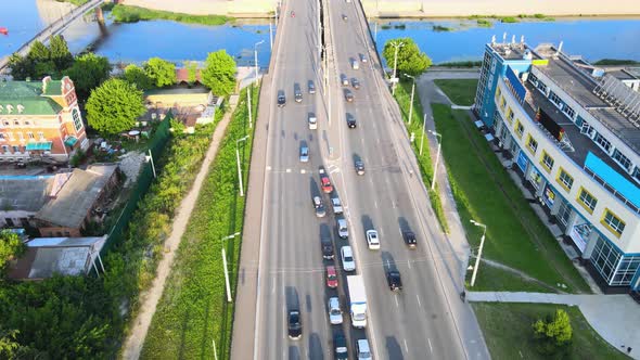 Car bridge across blue rivulet. Active movement of transport cars. Drone footage
