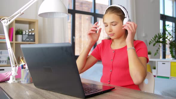 Girl in Headphones with Laptop Computer at Home
