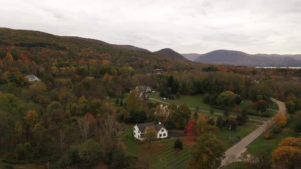 An aerial drone shot of the colorful fall foliage in upstate NY. The camera dolly in over treetops i