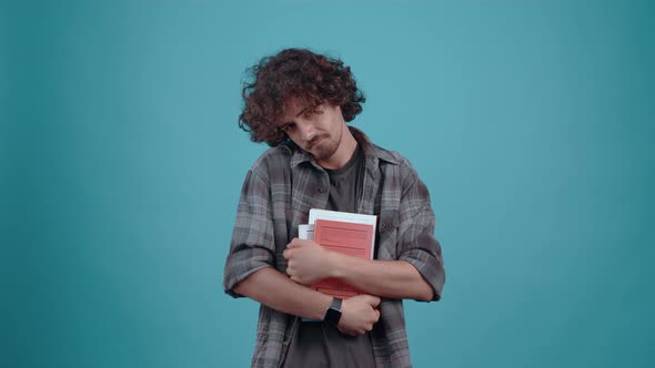 The Charismatic Chalky Young Man Holds a Few Books in His Hand and Emphasizes the Need to Read By