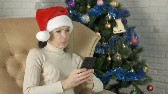 Sad female with phone on Christmas party.