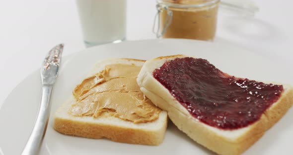 Close up view of peanut butter and jelly sandwich in a plate with copy space on white surface