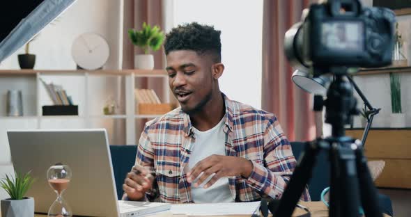 Black-Skinned Guy Working on Computer and Recording Videovlog for Internet Spectators