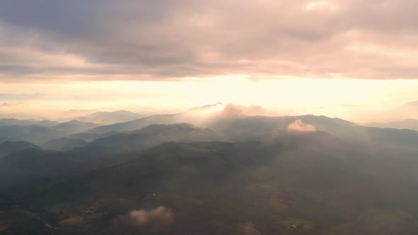 4K aerial view from a drone flying over the valley, fog in the morning.