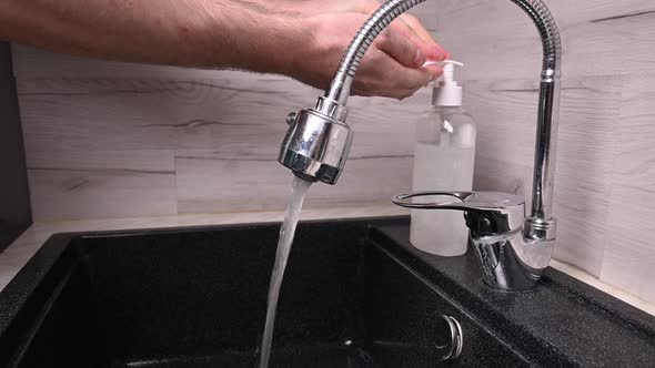 A Man Washes His Hands with Antibacterial Soap, Hygiene During Pandemic Covid-19