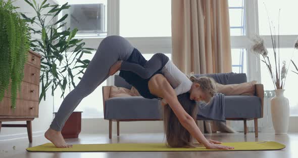 Young Beautiful Woman and Her Little Baby Girl Training Stretching Yoga at Home