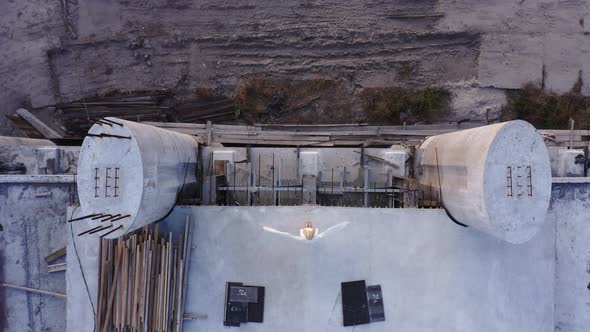 A beautiful angel among the ruins and abandoned buildings stands on the edge of the bridge