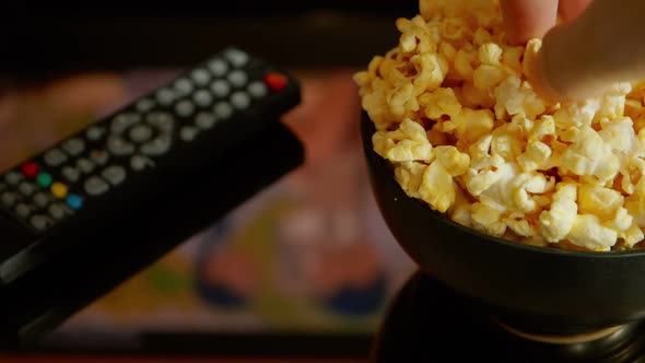 Close up, A man eating  popcorn while watching a movie in the living room.