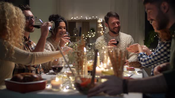 Happy Friends Drinking Red Wine at Christmas Party