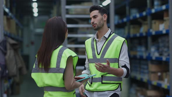 Middle Eastern Warehouse Worker Calming Down Supporting Upset Caucasian Colleague at Workplace