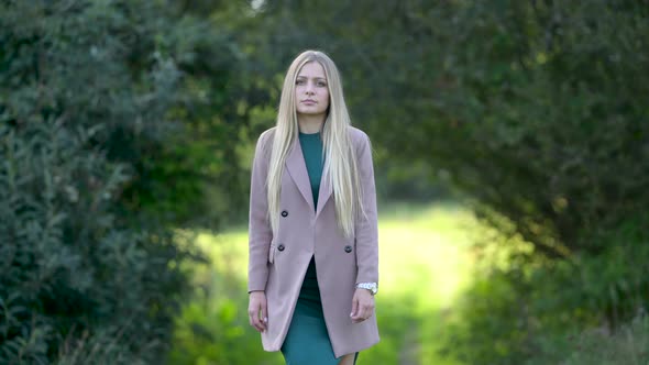 Portrait of an attractive blonde woman walking in the park on a sunny day