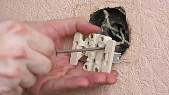 A professional electrician replaces the socket when renovating and constructing buildings. Close-up