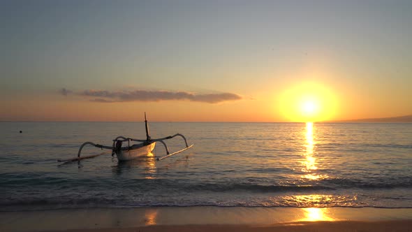 Time Lapse of Unknown Fishing Boat on a Tropical Beach with Golden Sea Background at Beautiful