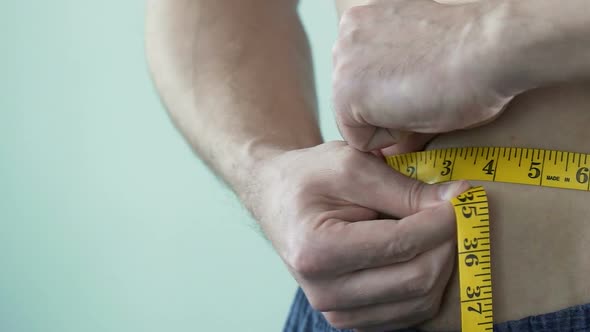 Male Taking Belly Measurements Using Tape, Weight Loss and Dieting, Close-Up