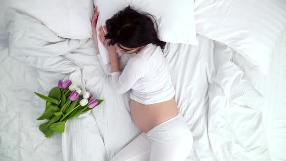 Flowers For Pregnant Woman. Beautiful Female Sleeping In Bed