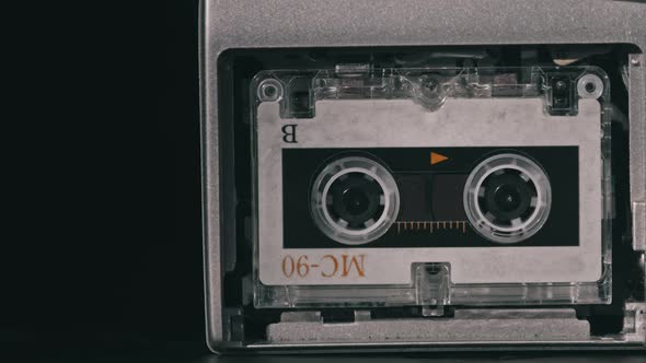 Vintage Audio Tape with a Blank Label Spinning in Cassette Recorder Closeup