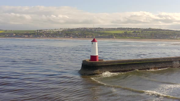 A Lighthouse and Breakwater at the Mouth of a Harbour in the UK