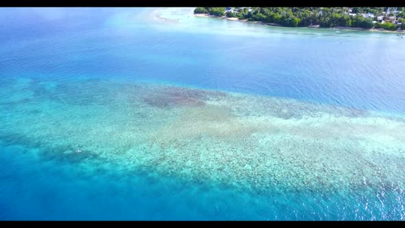 Aerial scenery of perfect coastline beach adventure by blue sea and white sandy background of a picn