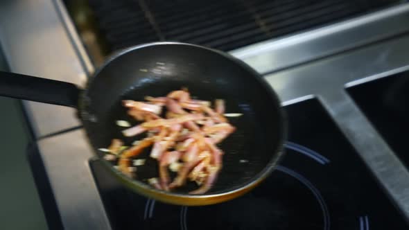 Cooking bacon for breakfast. Chef turns crispy bacon in frying pan. Ingredients for burger.