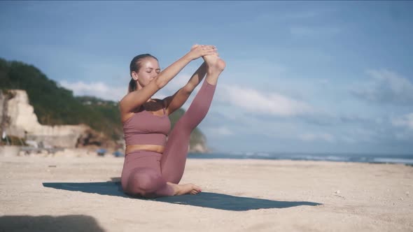 Girl in Tracksuit Stretches Left Leg By Doing Yoga Pose