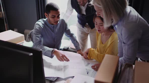 Group of people looking at blueprint in the office