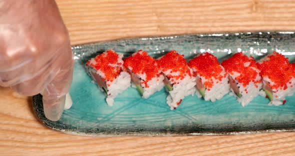 A Chef Squeeze And Puts Wasabi Paste On The Side Of A Sushi Rolls. - high angle  - slow motion