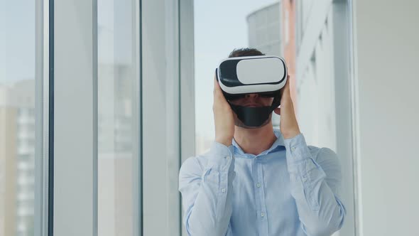 Close Up Young Man Sitting at a Desk in the Office Uses Augmented Reality Glasses To Work