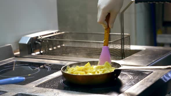 Cooking and stirring pasta in frying pan. 