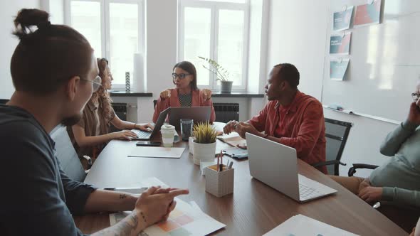 Female Leader Discussing Plans with Business Team at Office Meeting