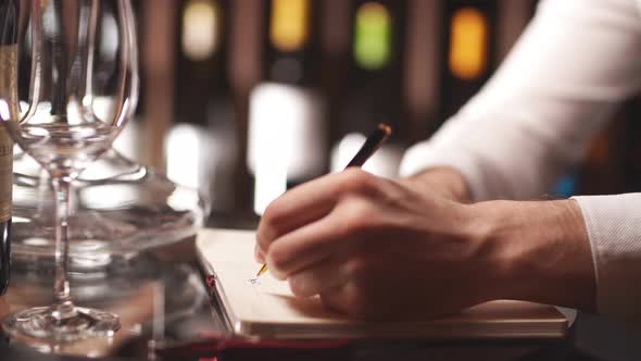 Experienced Male Wine Steward Doing Stocktaking of Wine at Store