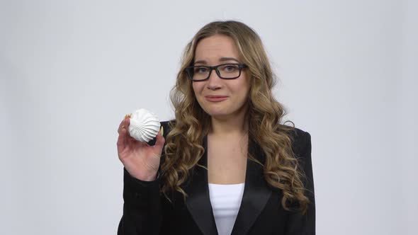 Hesitated Woman Holding Two Marshamallow and Wants To Eat It. Woman on Diet.