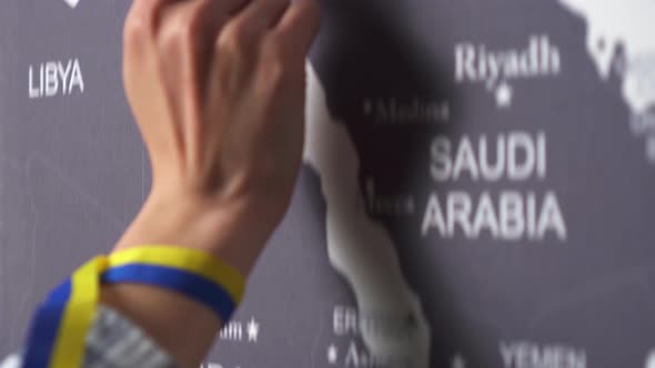 A Hand With A Ribbon From The Ukrainian Flag Shows Ukraine With Its Capital Kyiv On The World Map