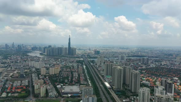 Drone dolly in shot from luxury high rise buildings and freeway towards epic city skyline and river