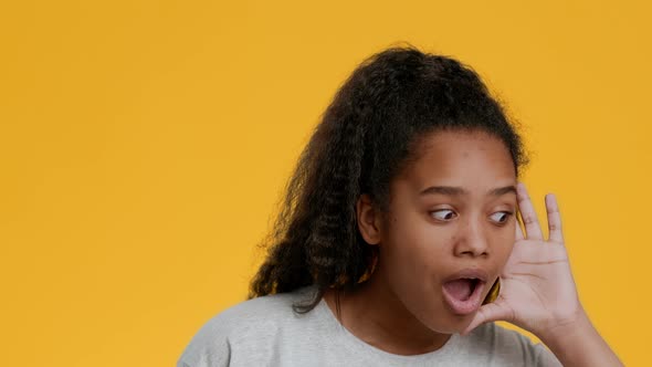 Curious African Girl Listening Holding Hand Near Ear Yellow Background