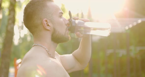 Muscular Athlete Relaxing After Training on Sports Ground in Morning