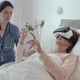 Female Doctor Checking on Elderly Patient Lying in Hospital Bed Doing Therapy Via VR Technology - VideoHive Item for Sale