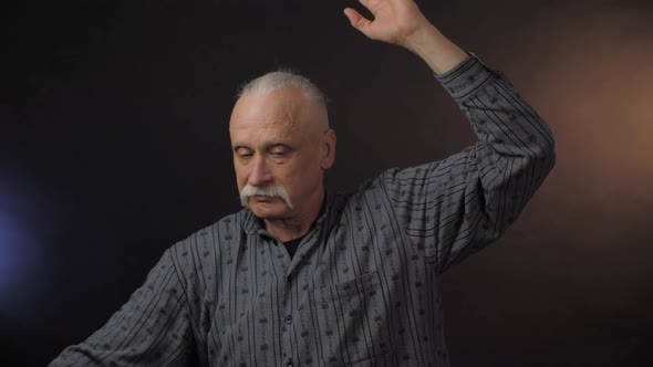 Aged Man with Trendy Grey Hair Bun Shows Ballerina Moves